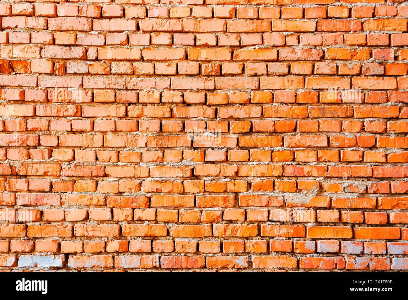 wide pattern of an orange brick wall. not finished or abandoned architecture development concept. dirty and uneven texture Stock Photo