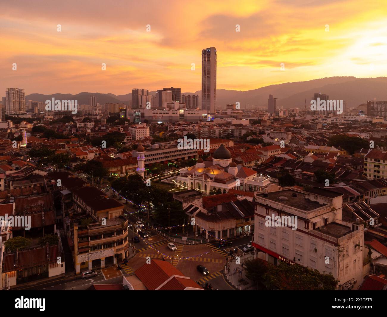 Penang, Malaysia - August 14 2022: The sun sets over Georgetown Little India and colonial district with the Kapitan Keling Mosque Stock Photo