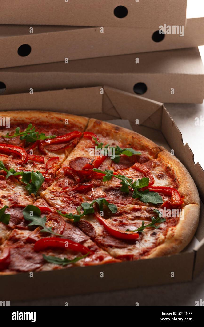 Large Pizza in open carton box on kitchen table closeup view Stock Photo