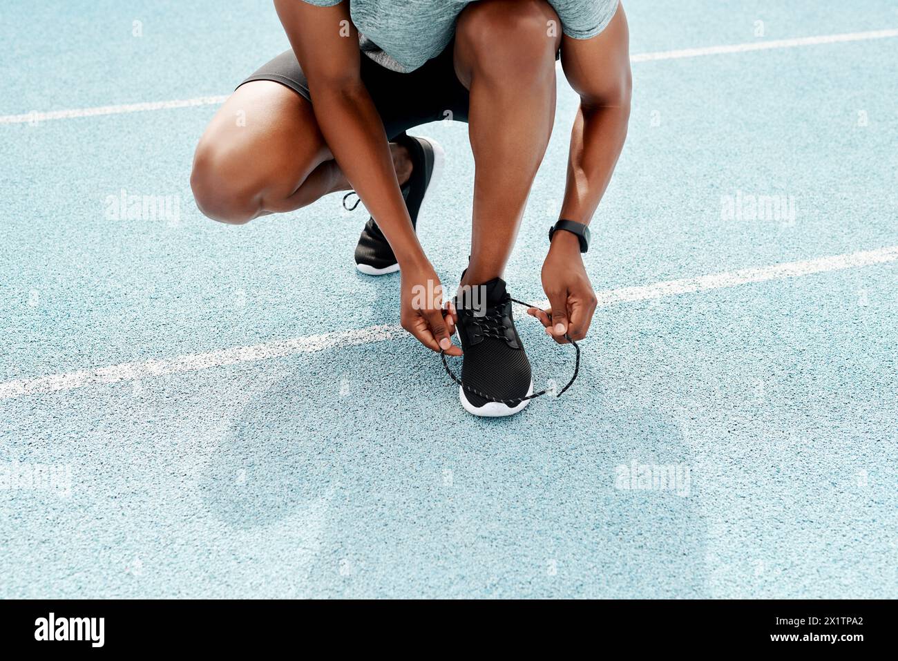 Running, shoes and hands of fitness man at stadium for training, workout or morning cardio. Shoelace, legs and runner at arena for race track exercise Stock Photo