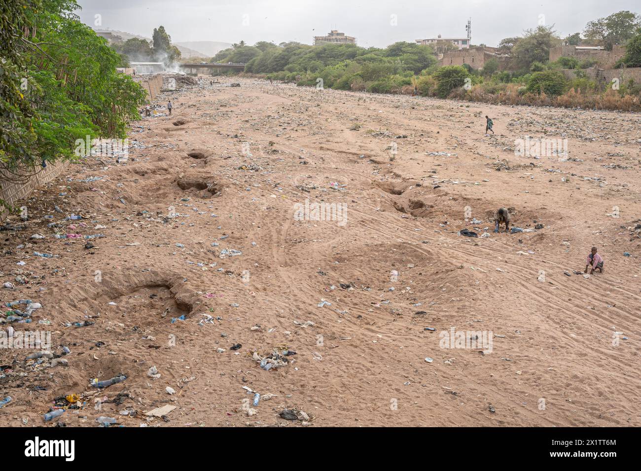 View of a dry river bed littered with piles of trash, mostly plastic, Djibouti Stock Photo