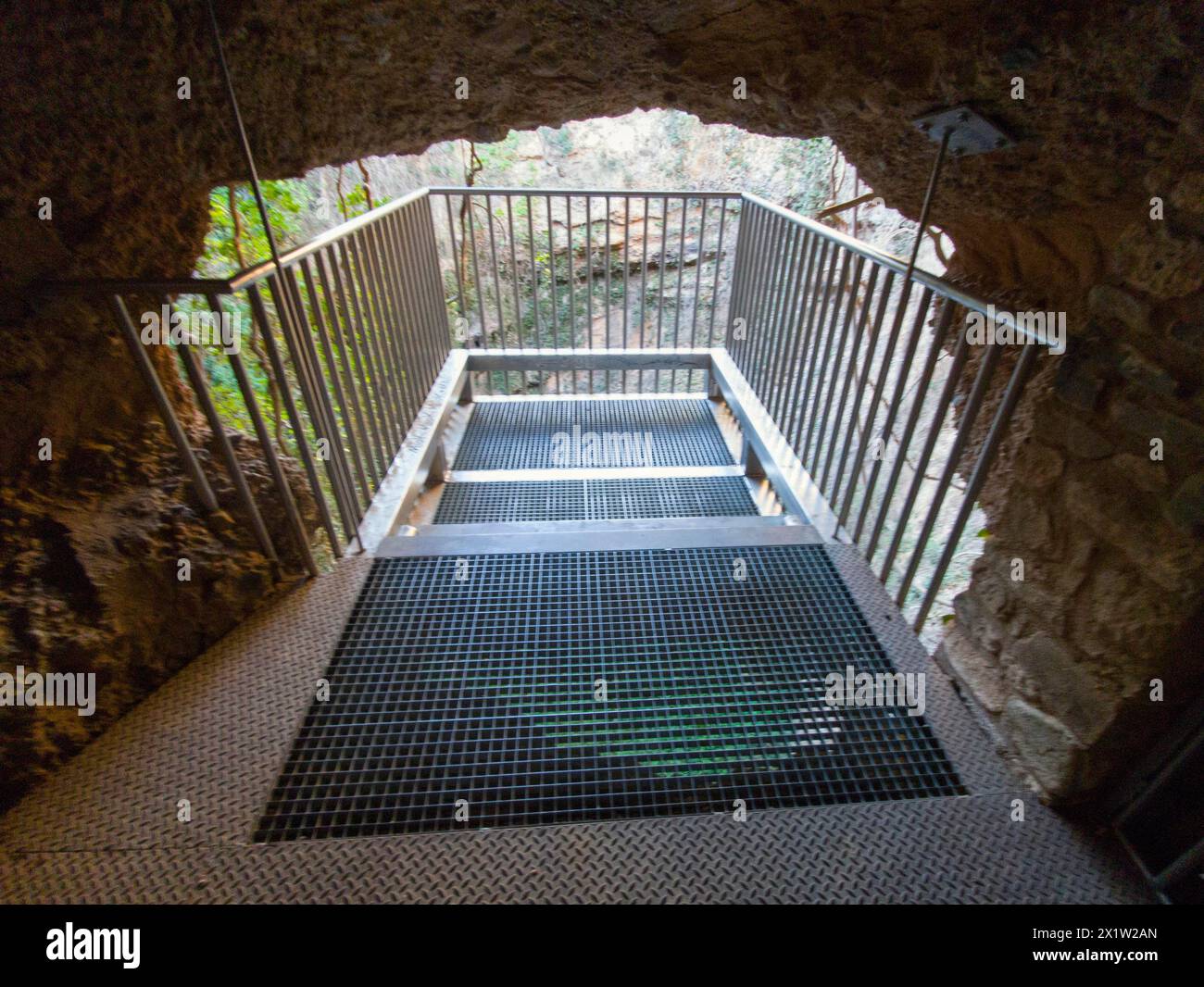 Metal lookout leads through a stone passageway in a cave structure, El Pozo de los Aines, Grisel, Tarazona, Spain Stock Photo