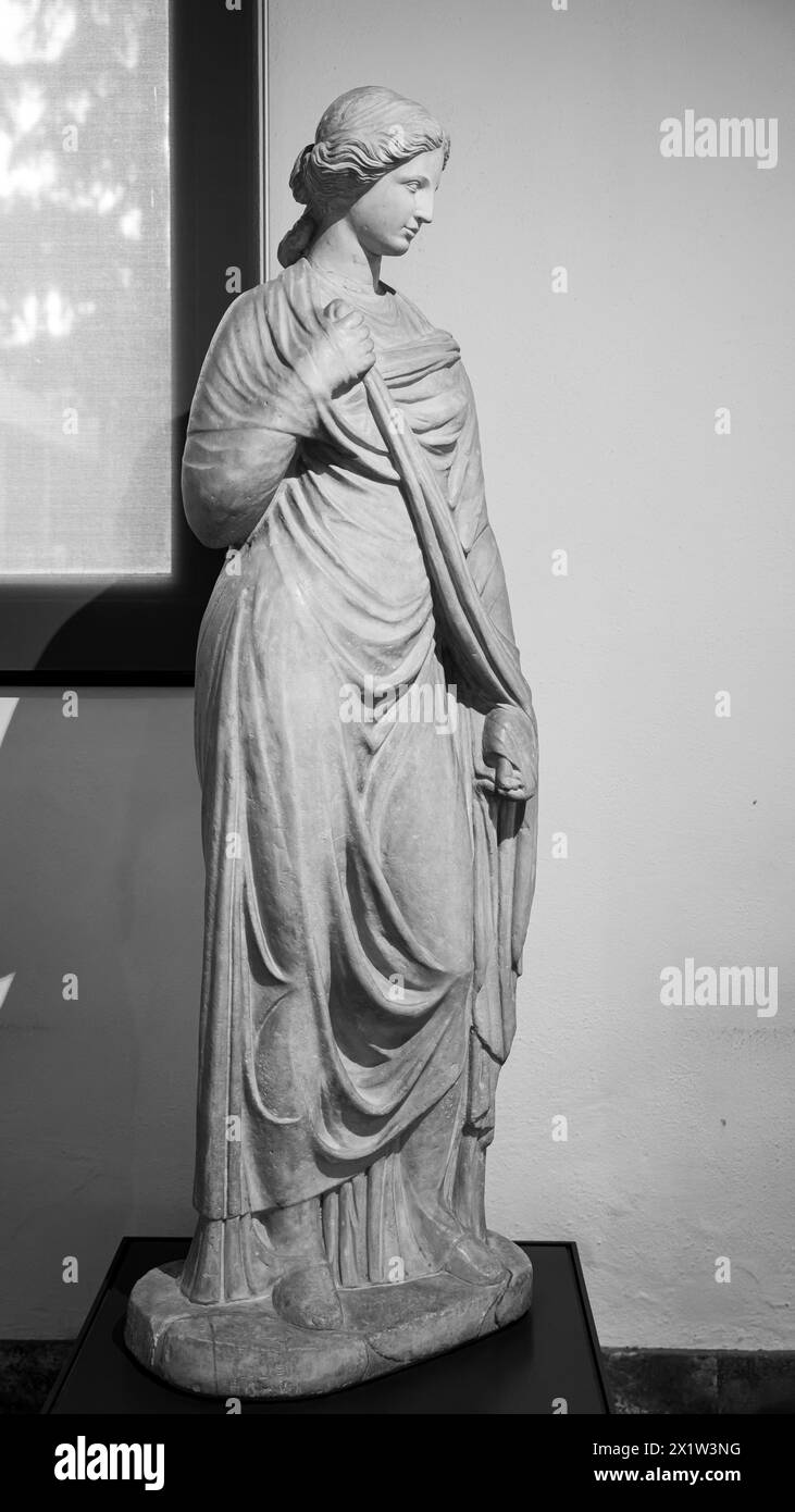 Black and white photo of classic sculpture in marble representing a roman young woman dressing a tunic Stock Photo