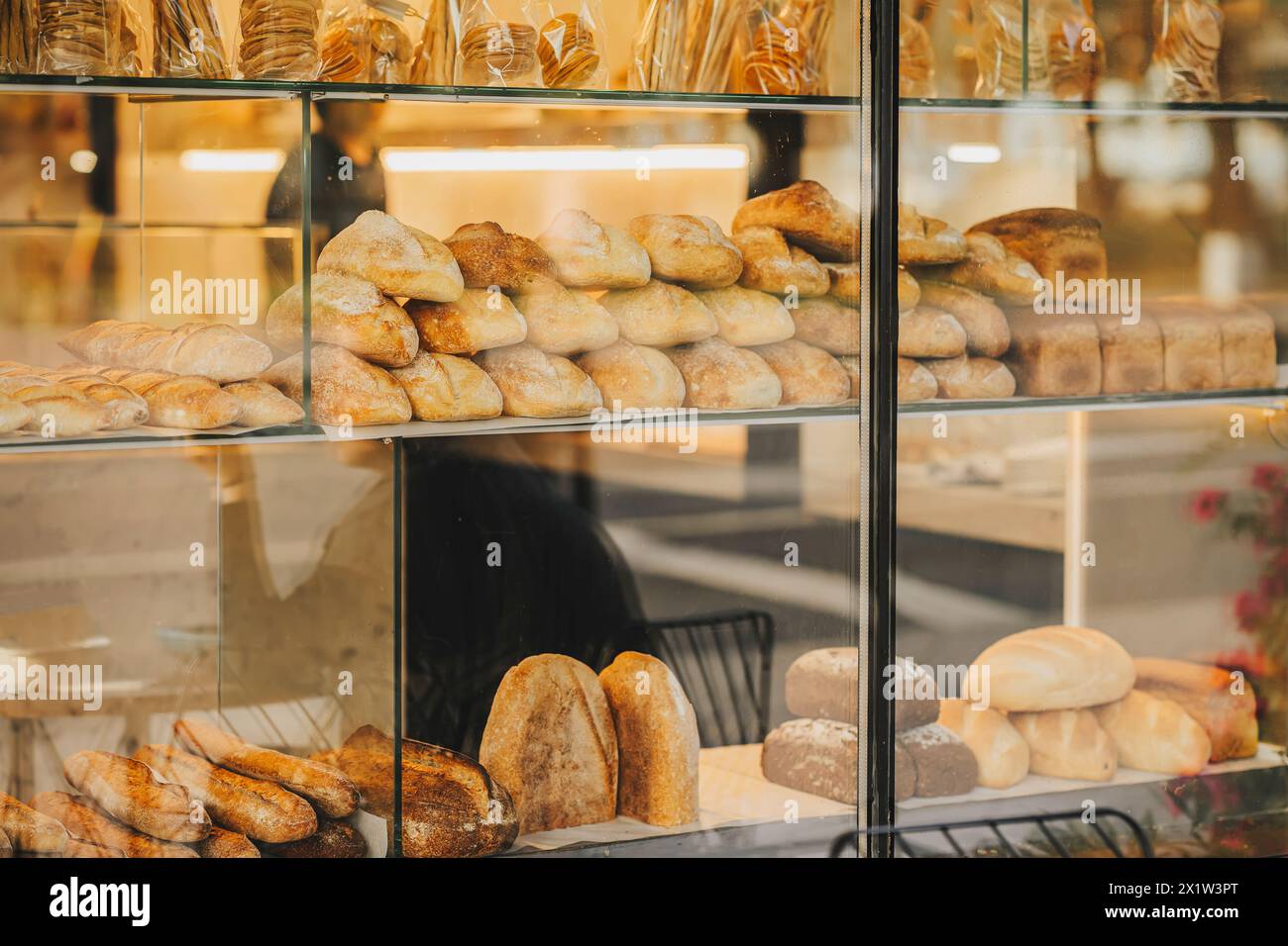 Bakery display case with variety of breads and pastries. Blurred view through store window Stock Photo
