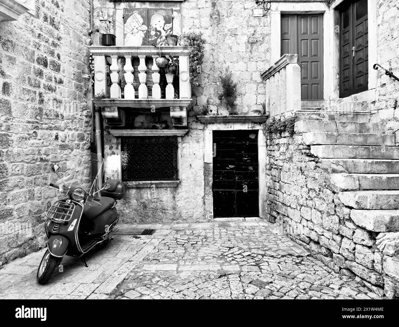Black and white picture of a Vespa in an old-fashioned alley, Trogir