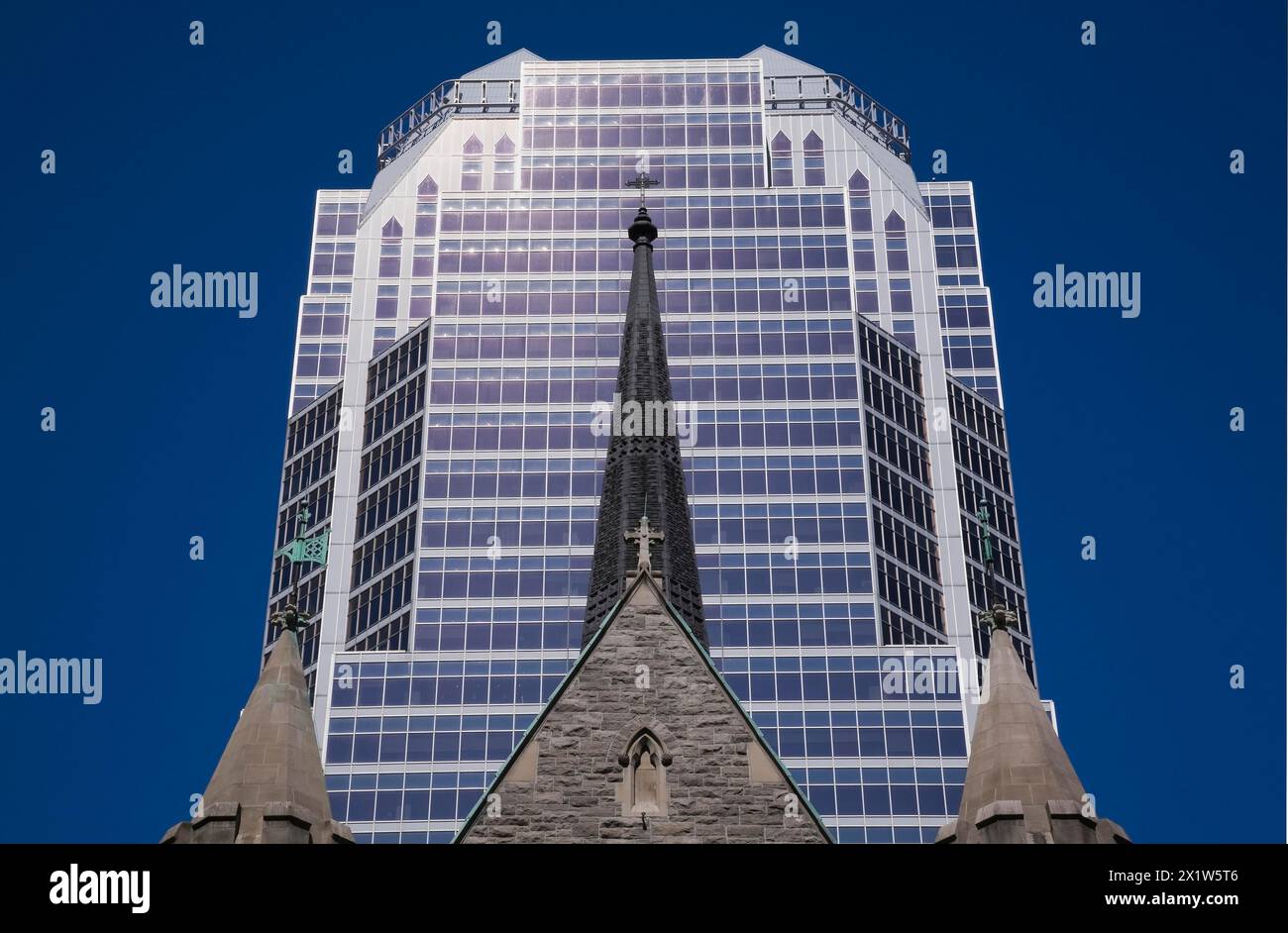 Old Christ Church Cathedral facade with spire and modern architectural steel and blue tinted glass windows KPMG office tower in summer, Montreal, Queb Stock Photo