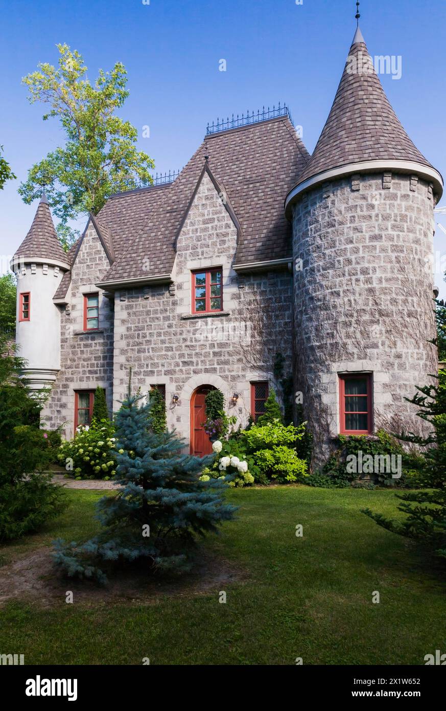 2006 reproduction of a 16th century grey stone and mortar Renaissance castle style residential home facade in summer, Quebec, Canada Stock Photo