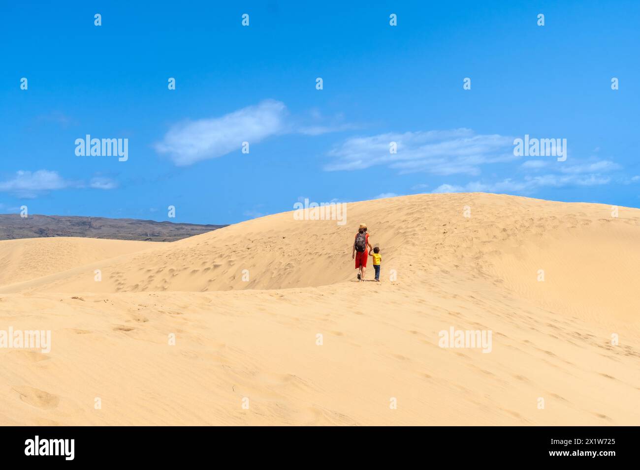 (Varios valores) Mother and son walking in the dunes of Maspalomas on vacation, Gran Canaria, Canary Islands Stock Photo