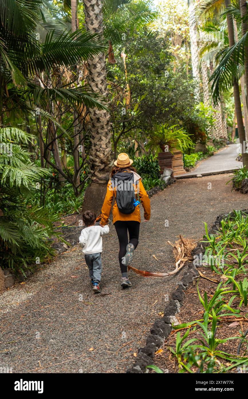 A mother and child enjoying and walking in a botanical garden. Family vacation concept Stock Photo