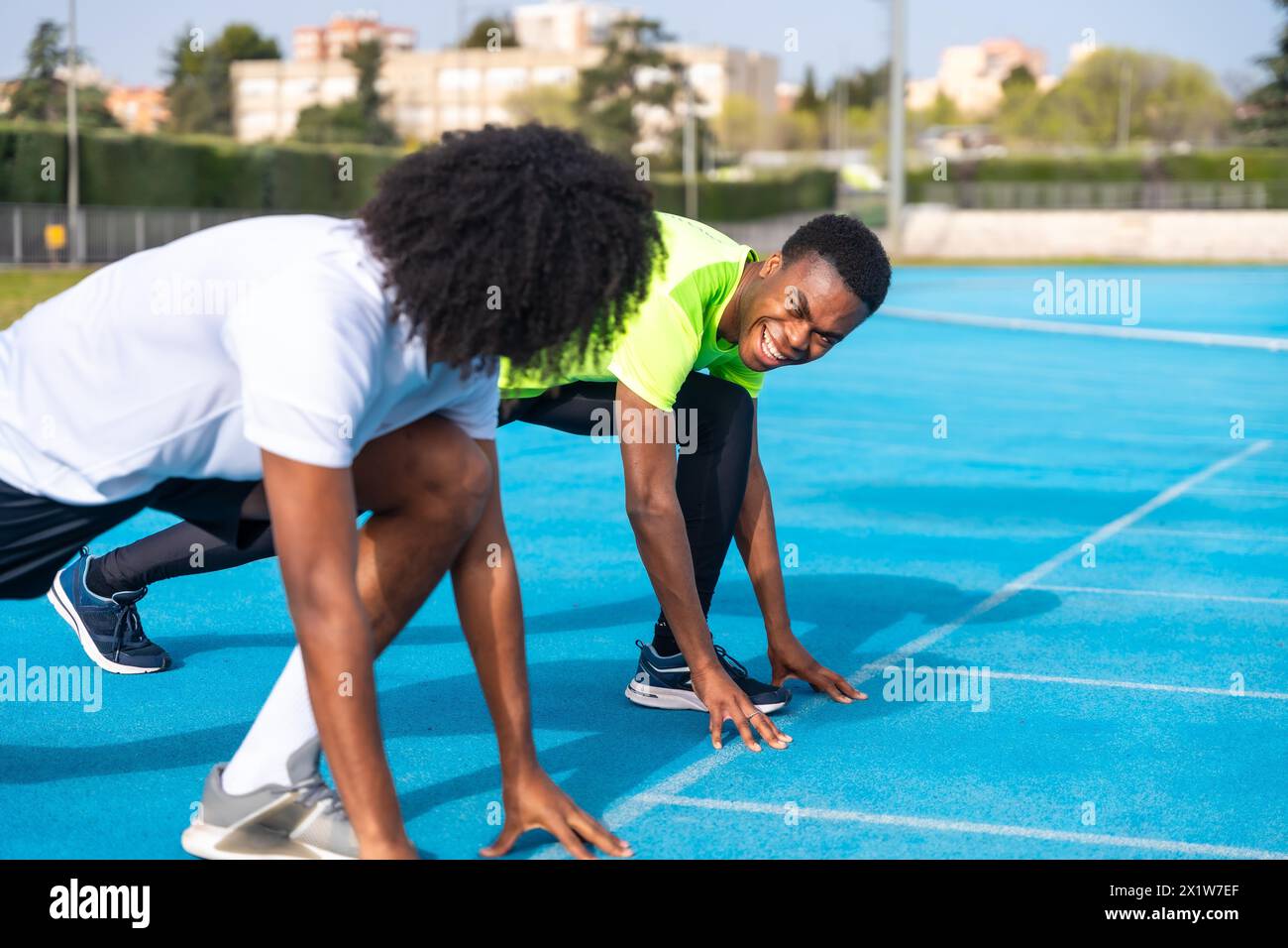African athletes in starting position to begin running on an athletics track Stock Photo