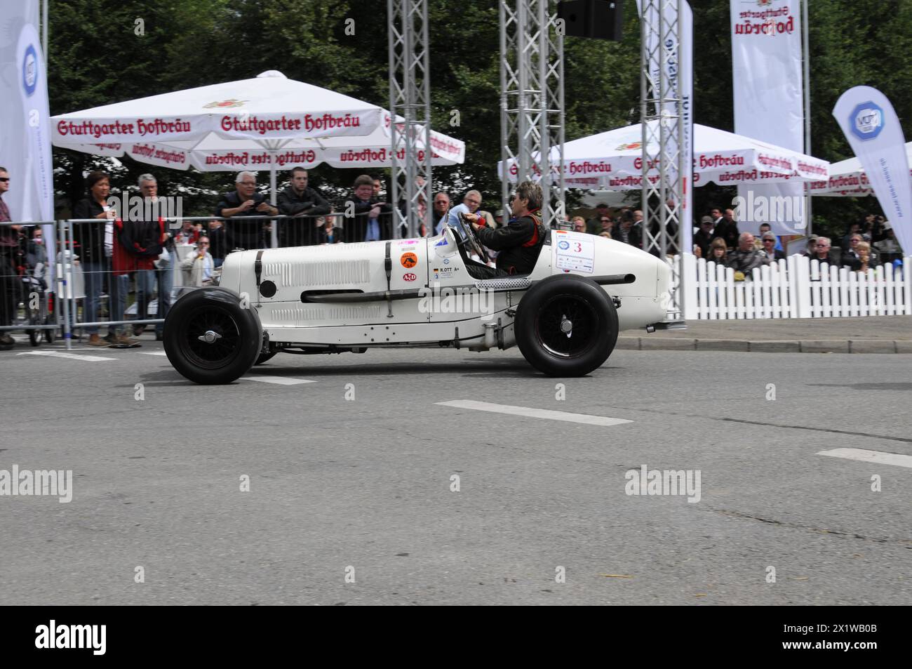A vintage racing car drives past a crowd of people and advertising banners, SOLITUDE REVIVAL 2011, Stuttgart, Baden-Wuerttemberg, Germany Stock Photo