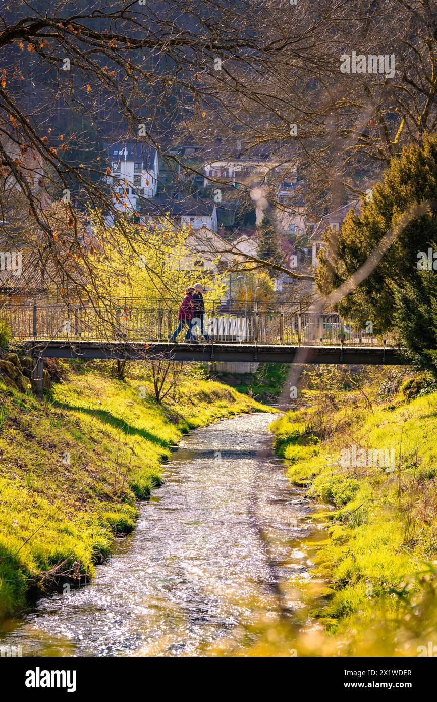 Two people meeting on a bridge over a river, spring, Calw, Black Forest, Germany Stock Photo