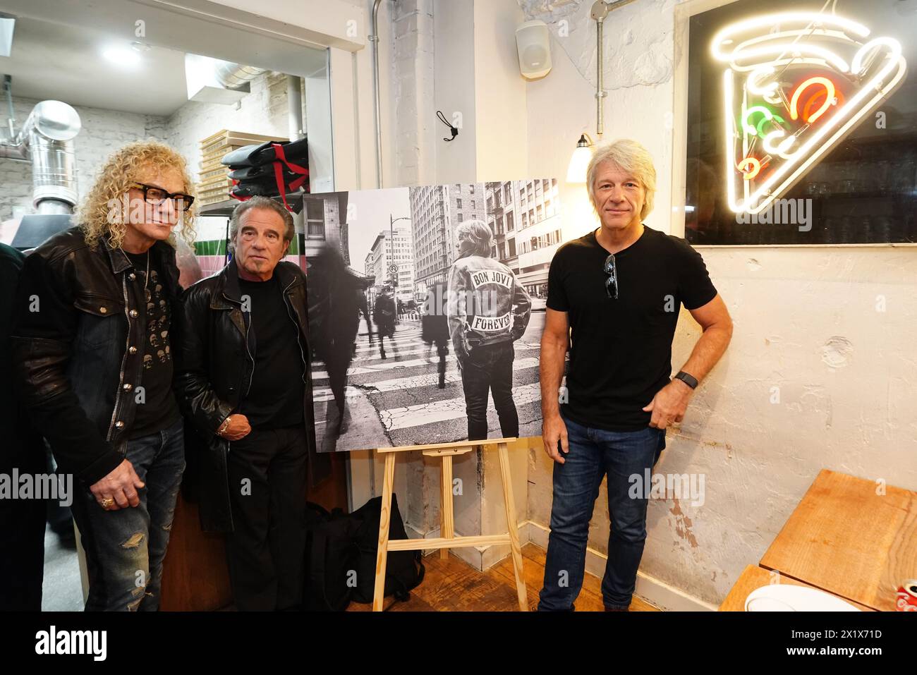 David Bryan, Tico Torres, and Jon Bon Jovi of American rock band Bon Jovi with fans during a pizza party and listening event for their new album 'Forever' in central London. Fans invited to the listening event for the album, which is released on June 7, were surprised when their music idols joined the London gathering. Picture date: Thursday April 18, 2024. Stock Photo