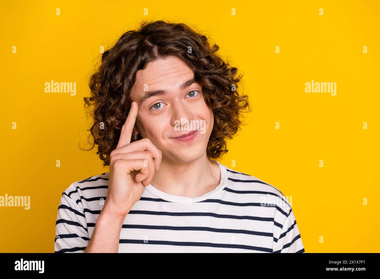 Portrait of young clever teenager guy touching forehead make decision deep thinking genius idea isolated on yellow color background Stock Photo