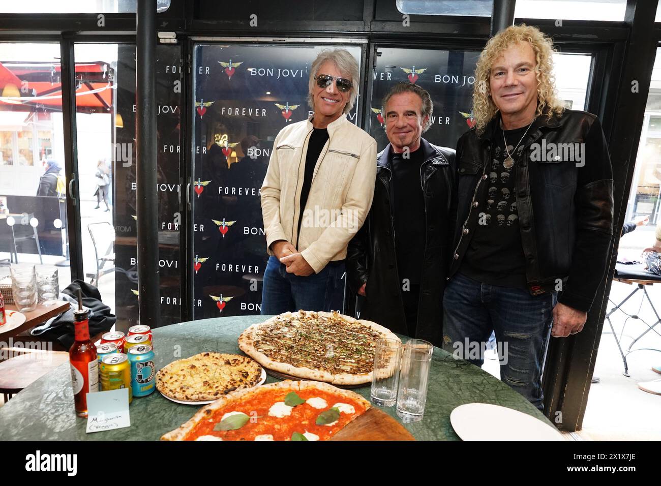 Jon Bon Jovi, Tico Torres, and David Bryan of American rock band Bon Jovi with fans during a pizza party and listening event for their new album 'Forever' in central London. Fans invited to the listening event for the album, which is released on June 7, were surprised when their music idols joined the London gathering. Picture date: Thursday April 18, 2024. Stock Photo