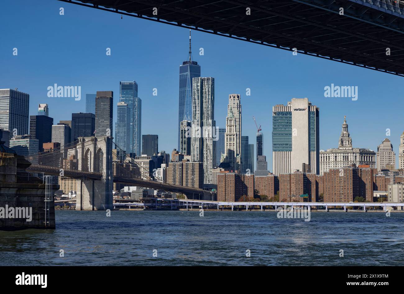 Lower Manhattan skyscrapers behind East River and Brooklyn Bridge seen from Main Street Park, below Manhattan Bridge, Brooklyn,  New York Stock Photo