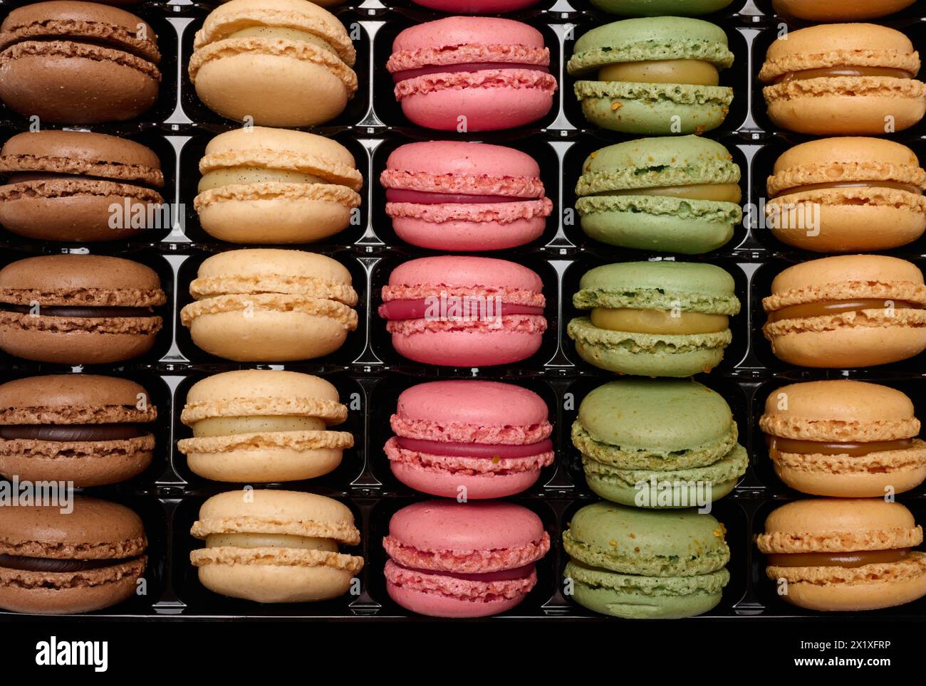 Multi-colored macarons in a plastic box, top view. Assortment Stock Photo