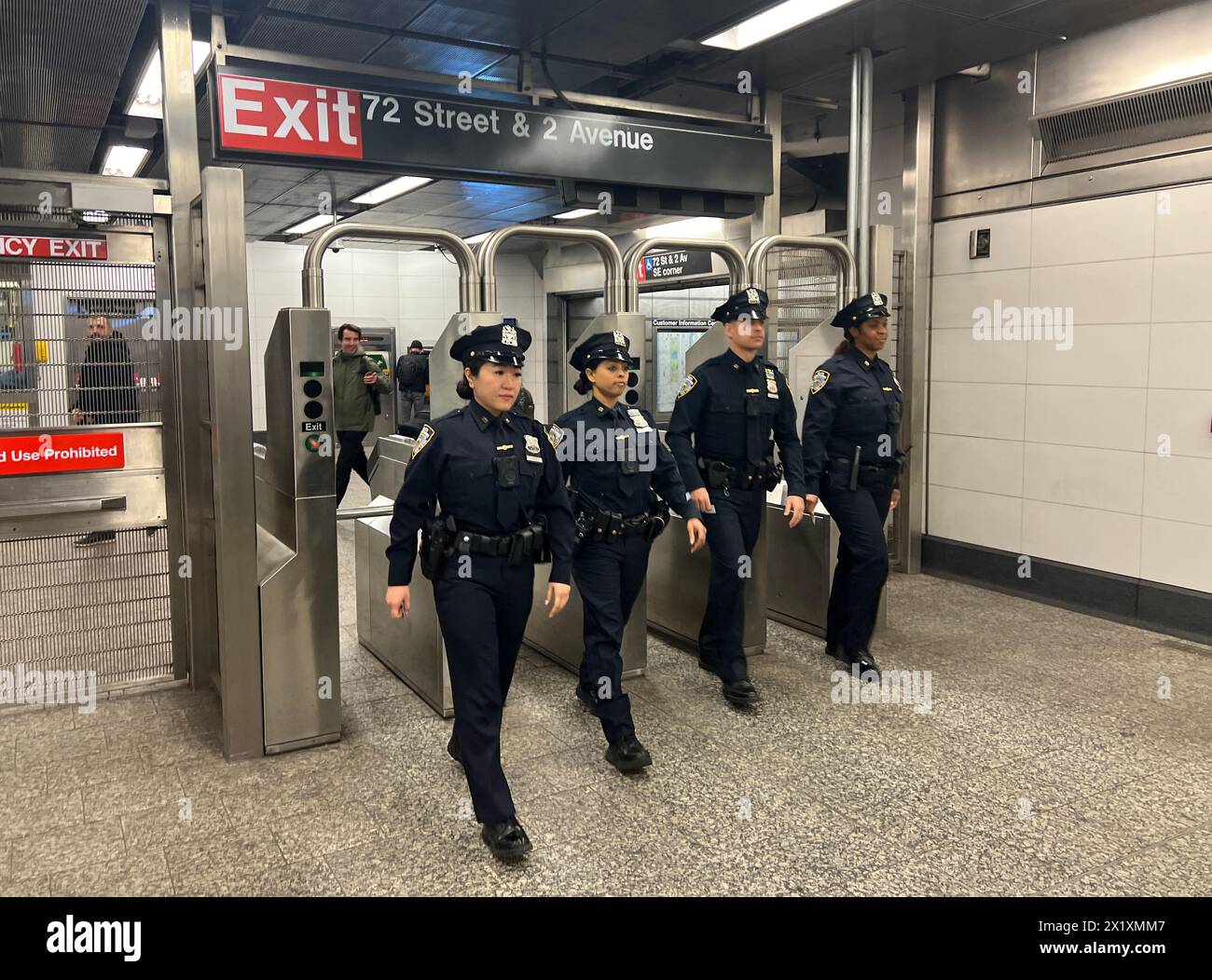 NYPD police officers march through a subway station turnstyle at the 72nds Street Q Train station in Manhattan, NYC. Stock Photo