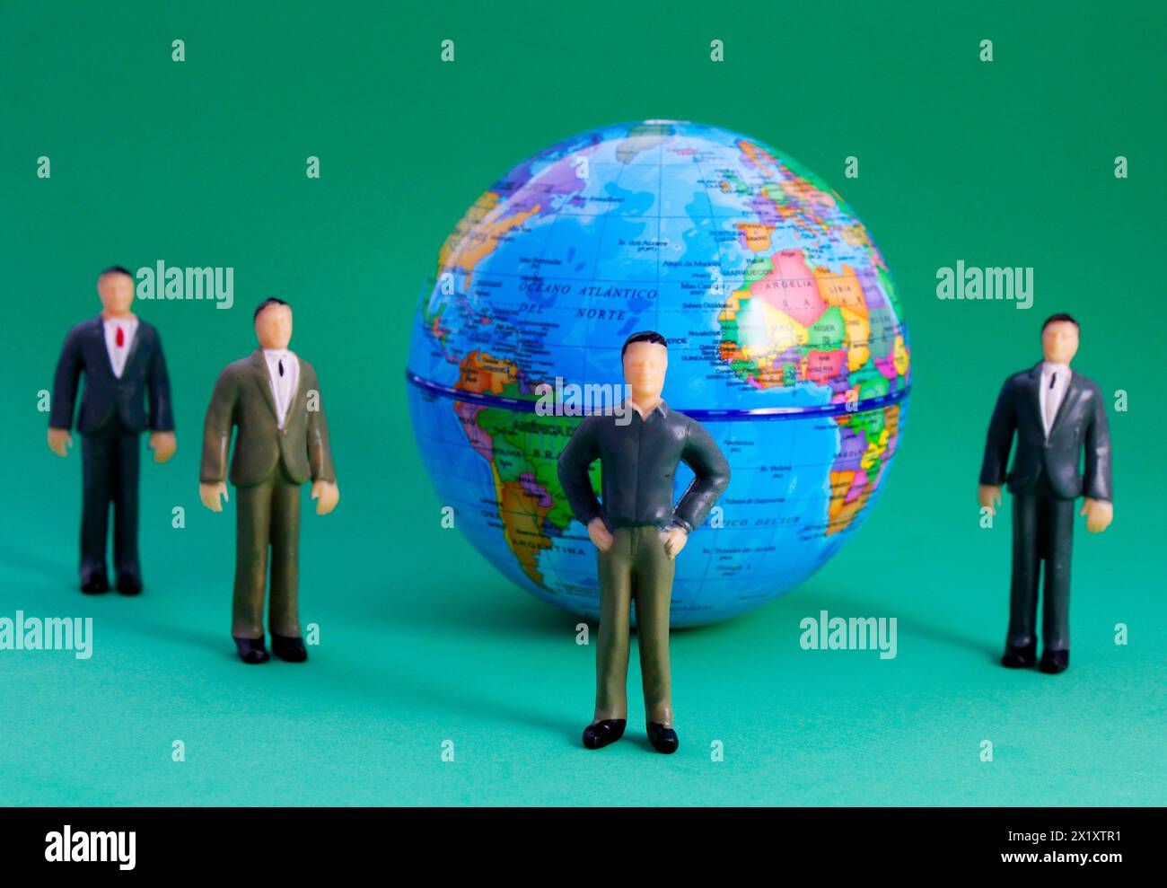 Men gathered around a sphere of the planet Earth (plastic human figure, map in Spanish) Stock Photo
