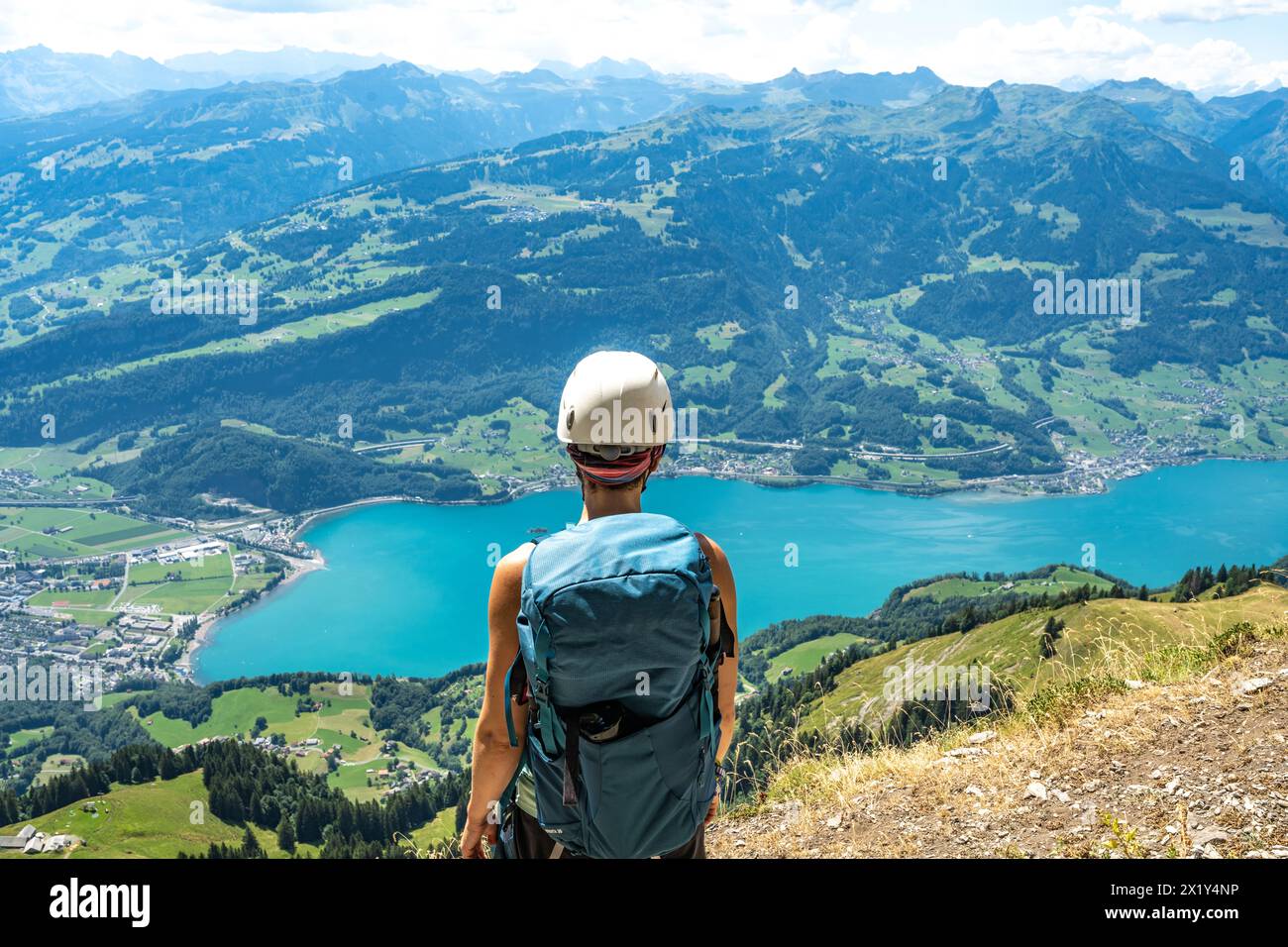 Walensee Background Description: Back view of sporty woman on a ledge enjoing the view of ...