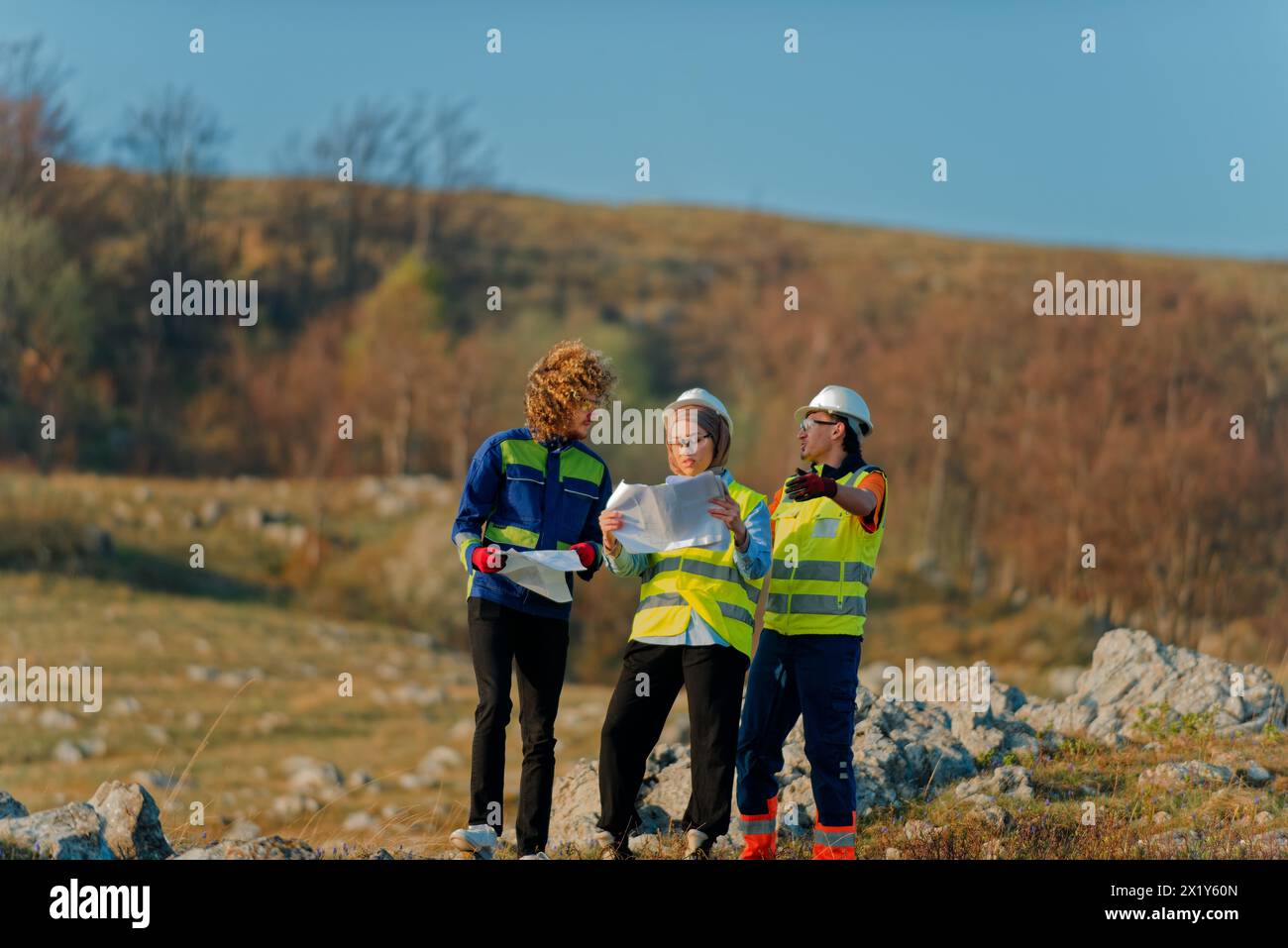 A team of engineers and workers oversees a wind turbine project at a ...