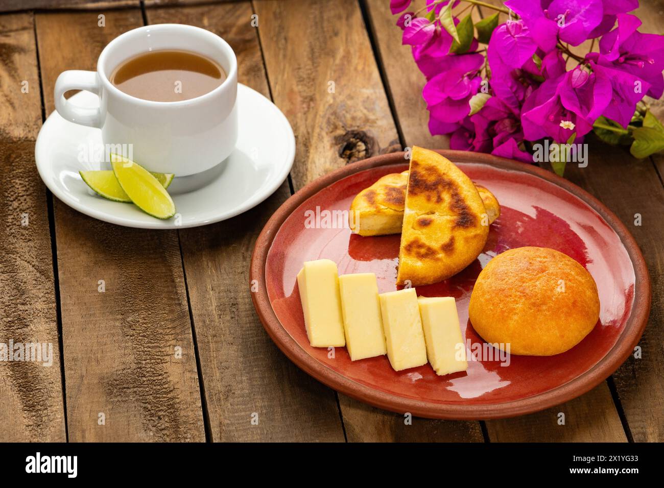 Breakfast served at the table - Arepa, almojabana, cheese and hot aguapanela. Colombian gastronomy Stock Photo