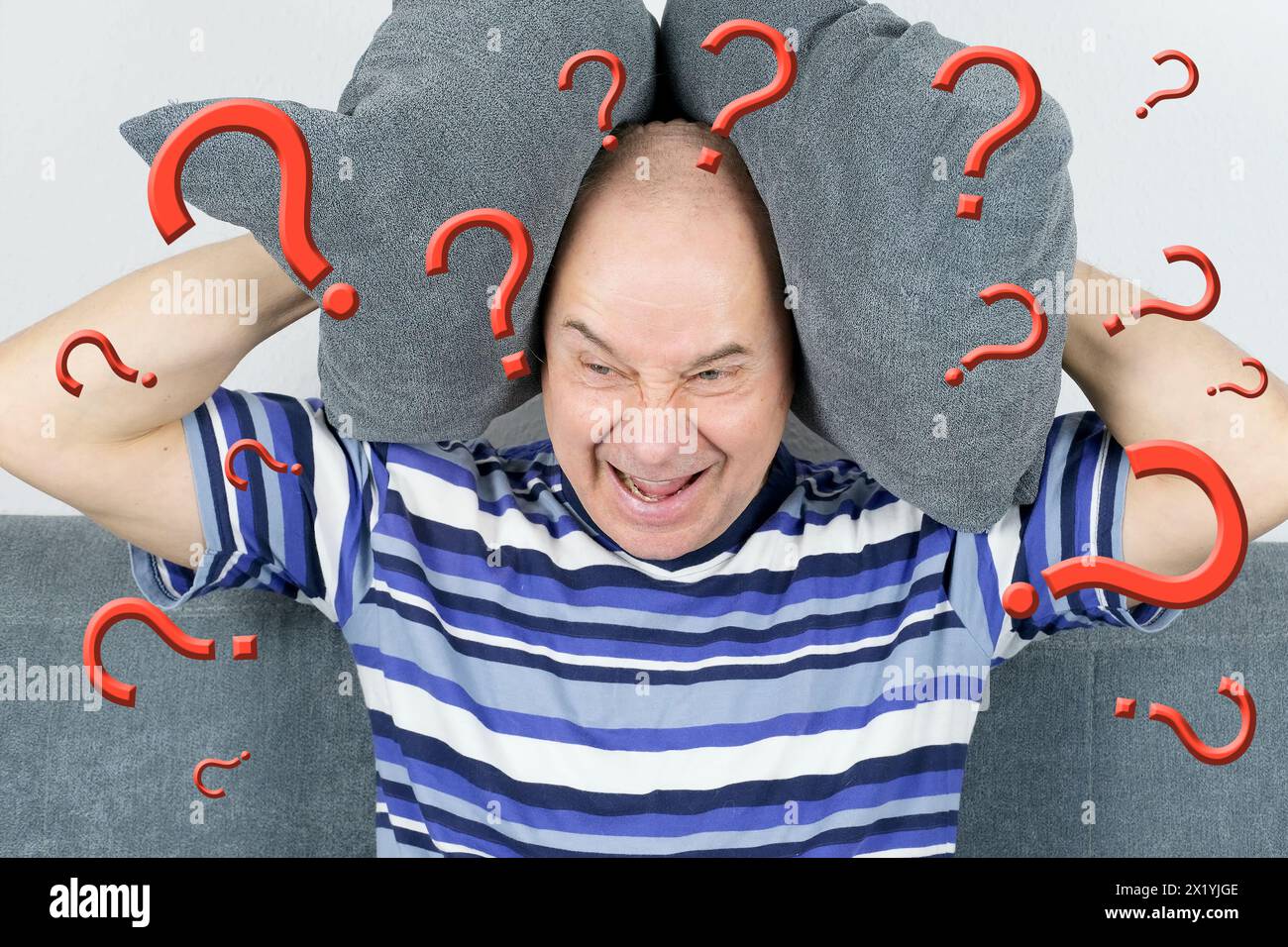 adult man sits on sofa, wrapped head in hands, question marks