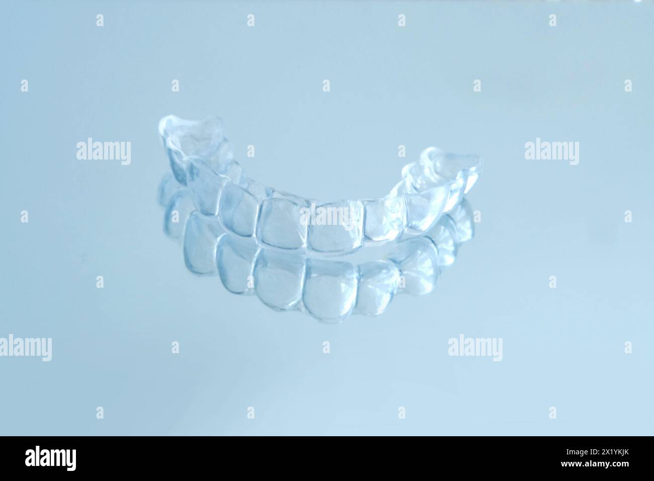 close-up of transparent Silicone Night Mouth Guard for Teeth Clenching Grinding Dental Bite Sleep Aid on a blue background, concept dental services, r Stock Photo