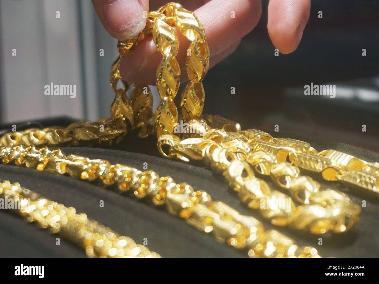 HANGZHOU, CHINA - APRIL 19, 2024 - An employee displays gold jewelry at a gold shop in Hangzhou, east China's Zhejiang province, April 19, 2024. Stock Photo