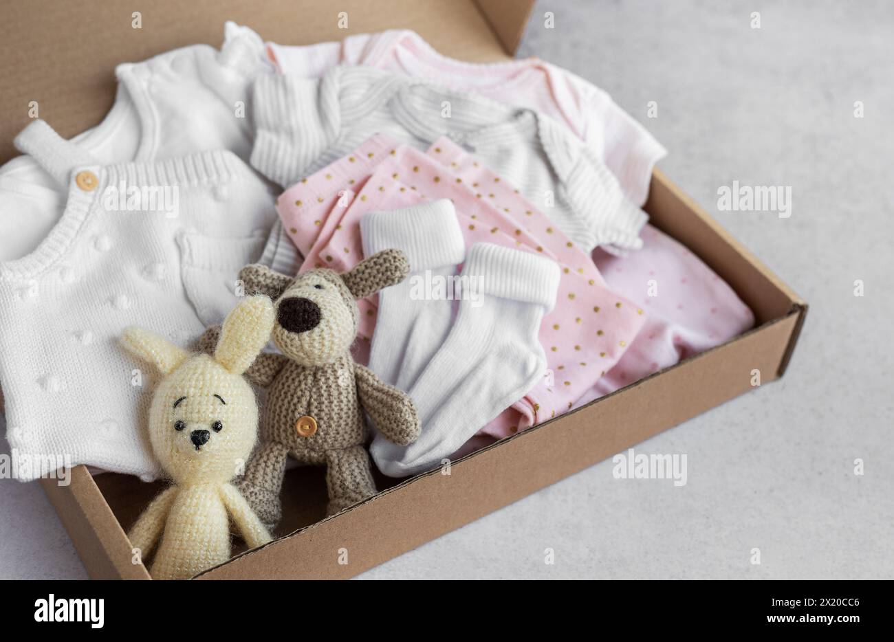 Baby and child clothes and knitted toys in carton box. Donation