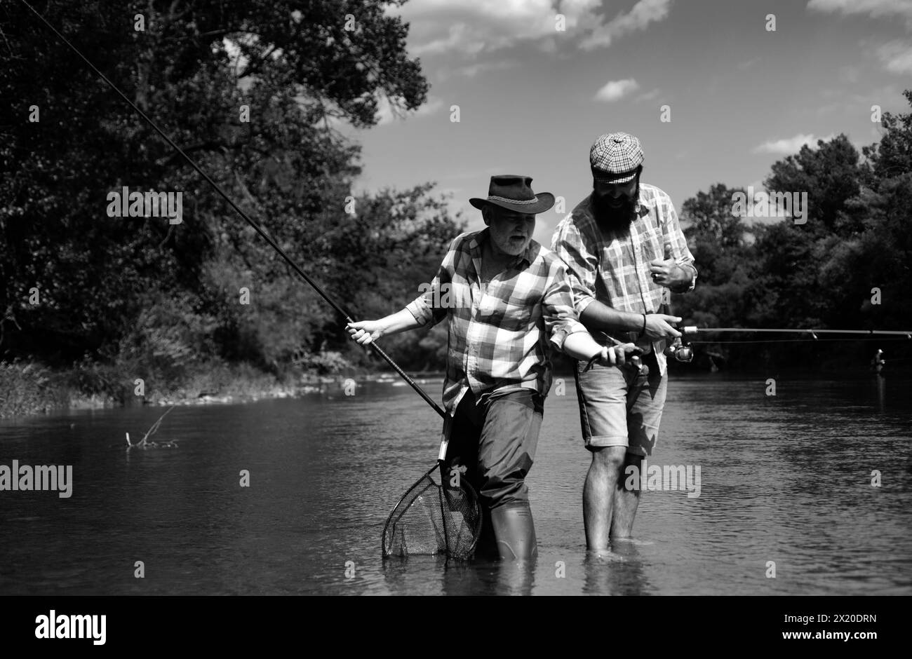 Father and son fishing at shore Black and White Stock Photos & Images ...
