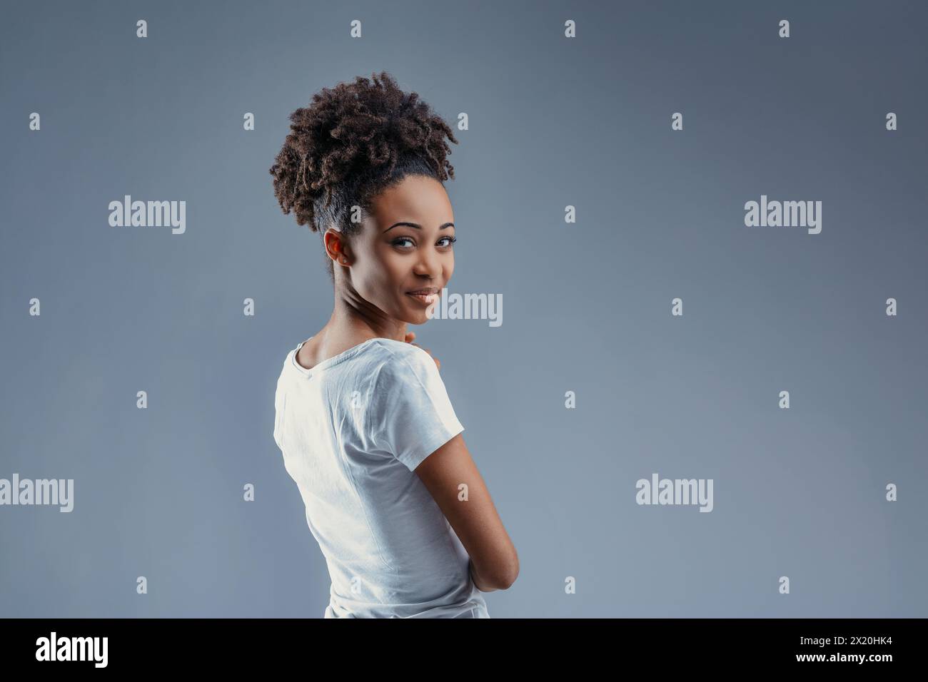 Half-turned, she offers a bright, cheeky smile, her Afro hairstyle ...