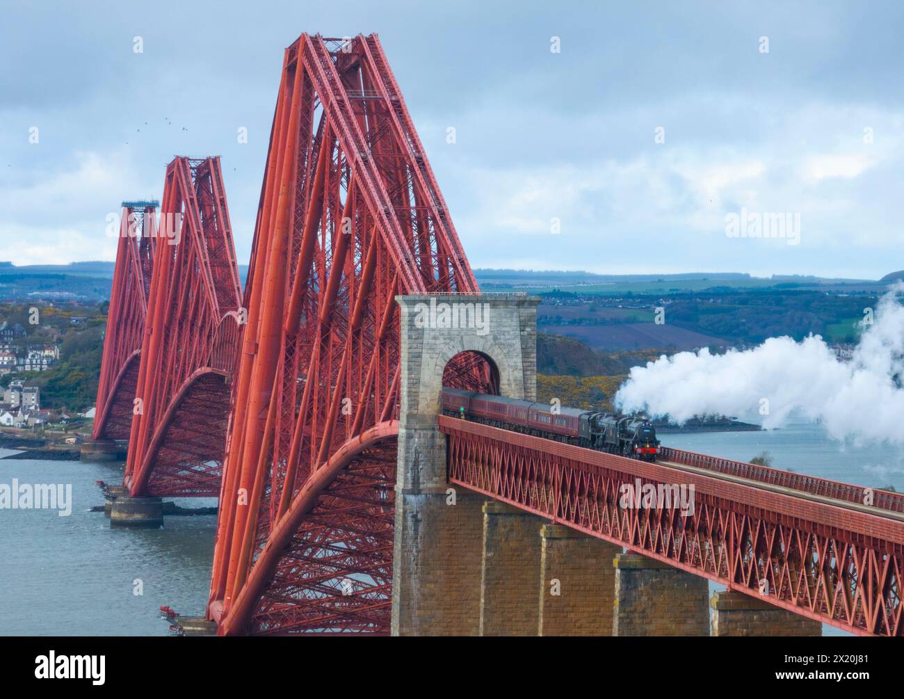 Two Black 5 class steam locomotives pulling carriages of steam enthusiasts travel across the Forth Bridge at South Queensferry, Scotland, Uk Stock Photo
