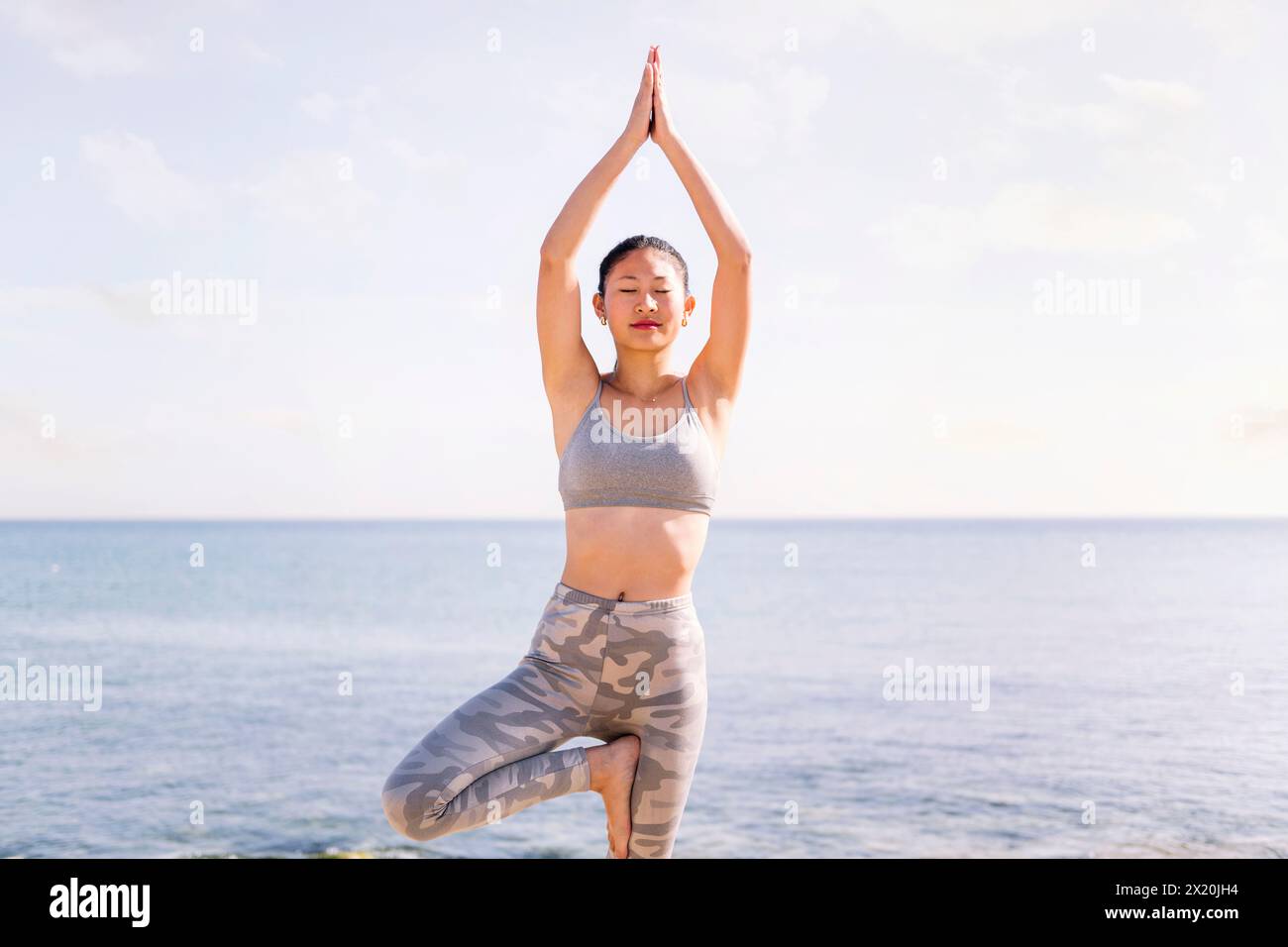 Young woman tree position beach hi-res stock photography and images - Alamy