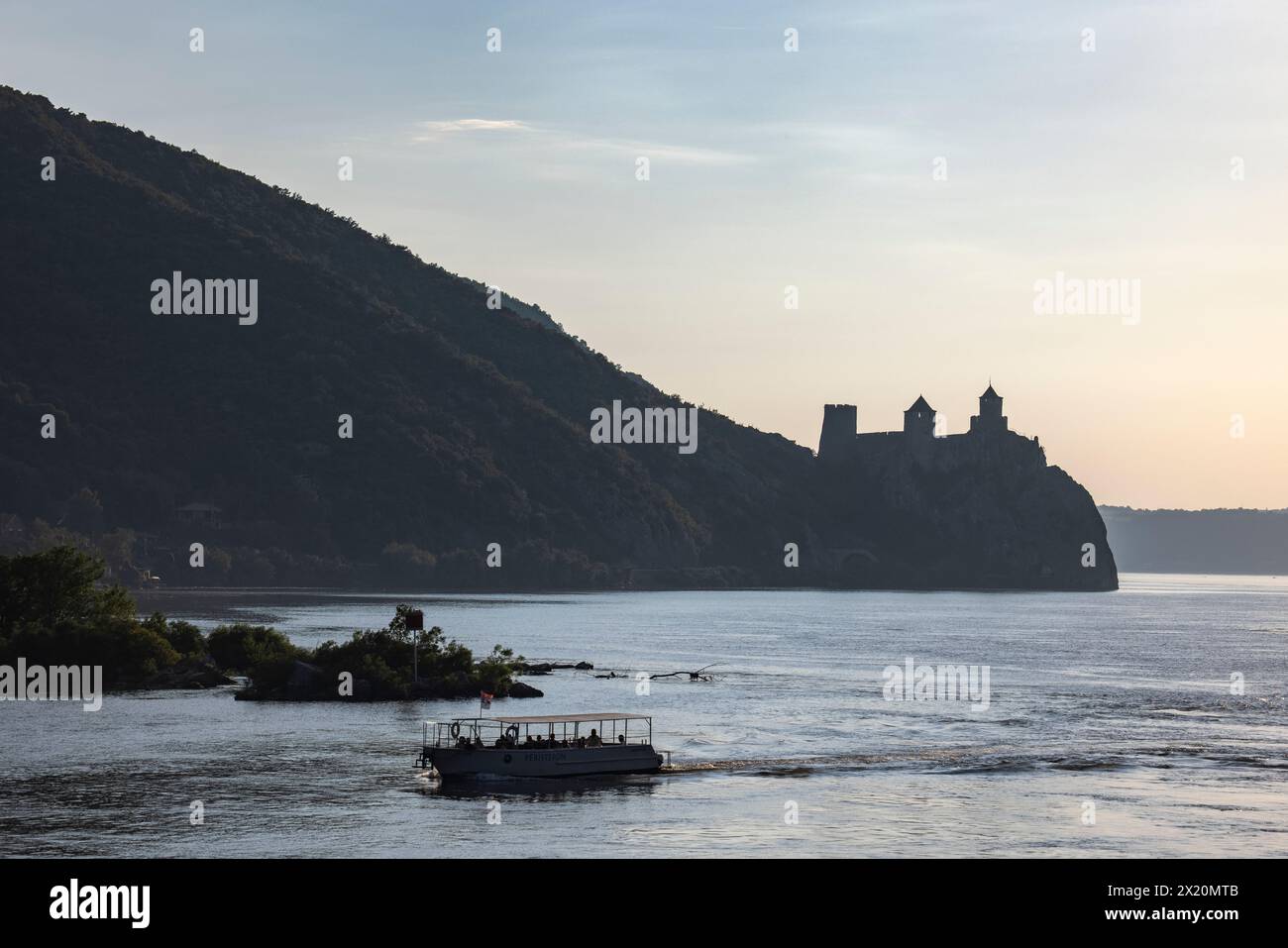 Silhouette of excursion boat in the Iron Gates gorge of the Danube with the Golubac Fortress in the distance, Golubac, Braničevo, Serbia, Europe Stock Photo