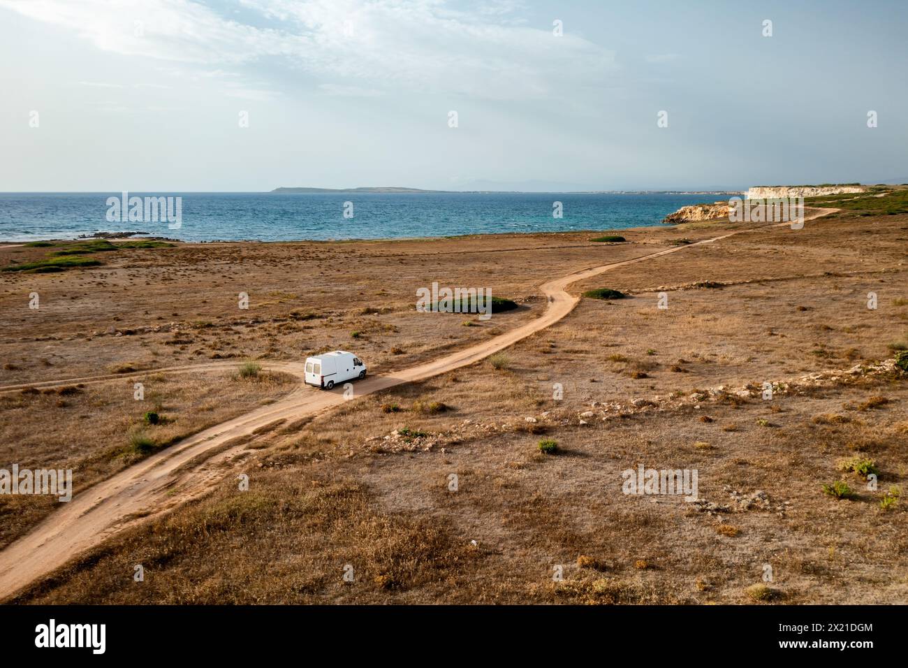 Camper van drone view driving on a wild landscape road with sea cliffs ...