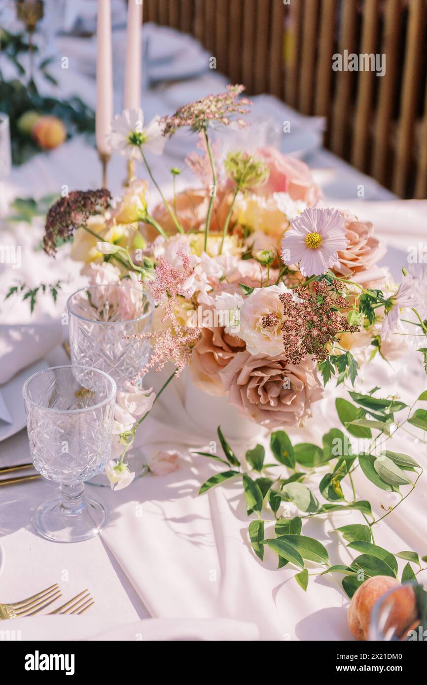 Sunlit outdoor wedding table setting with blush florals Stock Photo