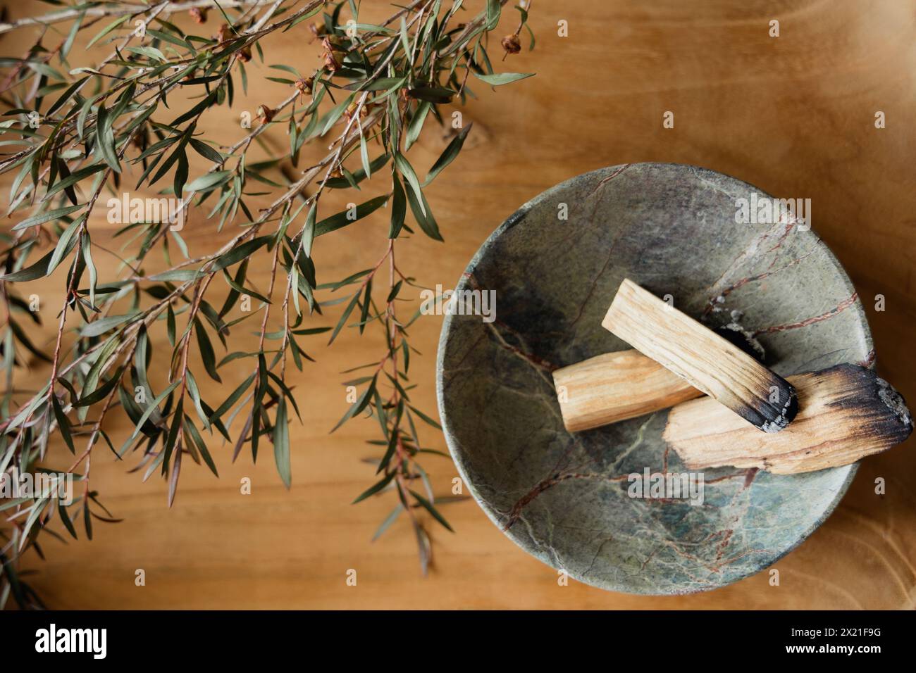 Palo Santo sticks in marble bowl with manuka on wooden background Stock ...