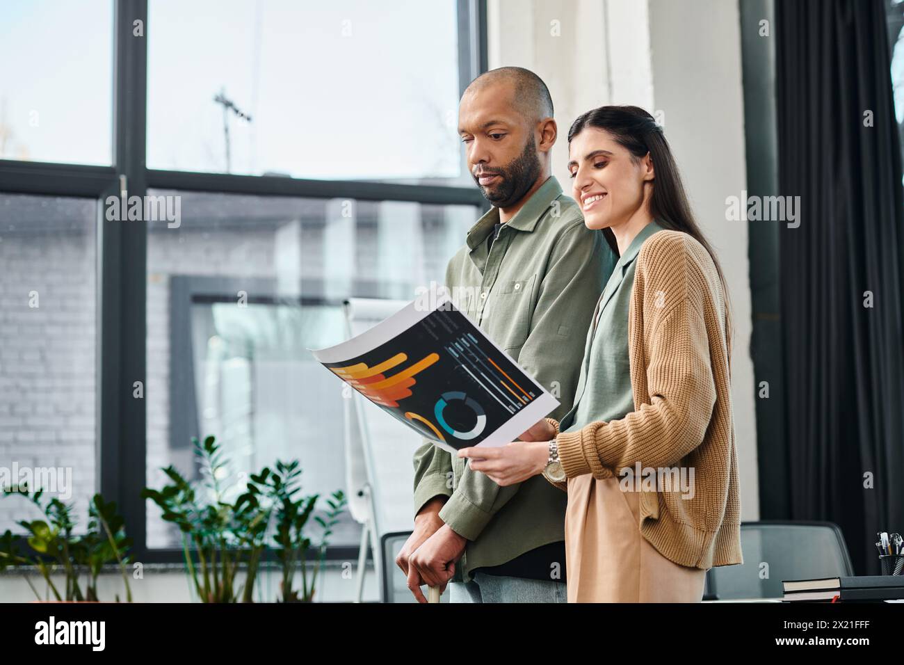 A man and a woman engrossed in charts, exploring ideas in a shared moment of intellectual connection. Stock Photo