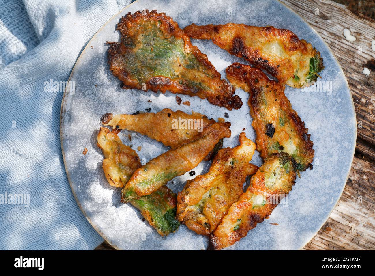 Making vegan plant-based potato chips with nettle leaves, step 5: Finished pastry sheets are arranged on a plate, series image 5/5 Stock Photo