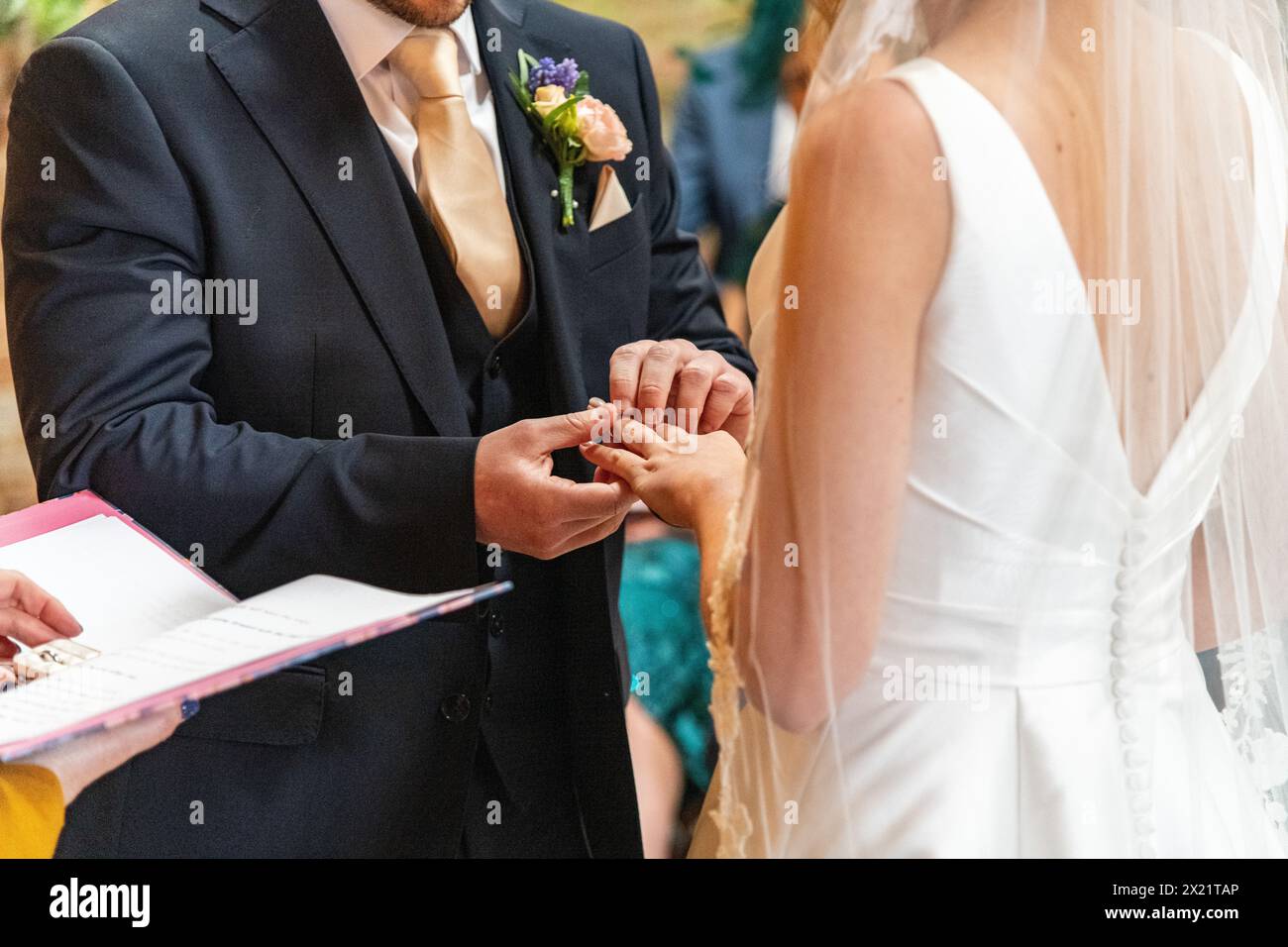 A bride and groom couple exchanging wedding vows and rings at a service ceremony during a wedding at Botley Hill Farm in Surrey, UK Stock Photo