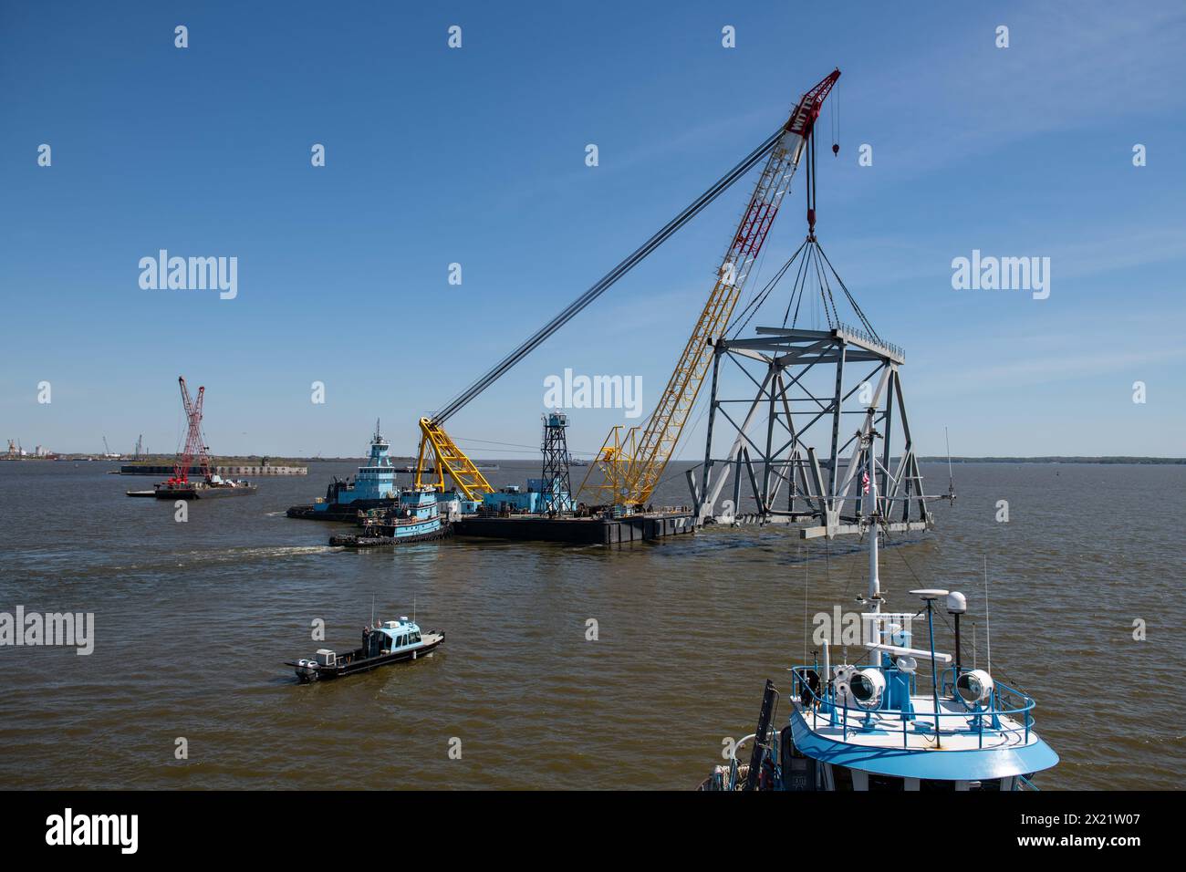 Dundalk, United States of America. 16 April, 2024. The Chesapeake, a 1000-ton lift capacity derrick barge lifts a section of the collapsed Francis Scott Key Bridge blocking the Fort McHenry channel, April 16, 2024, near Dundalk, Maryland. The bridge was struck by the 984-foot container ship on March 26th and collapsed killing six workers. Credit: MC2 Christine Montgomery/U.S Navy Photo/Alamy Live News Stock Photo