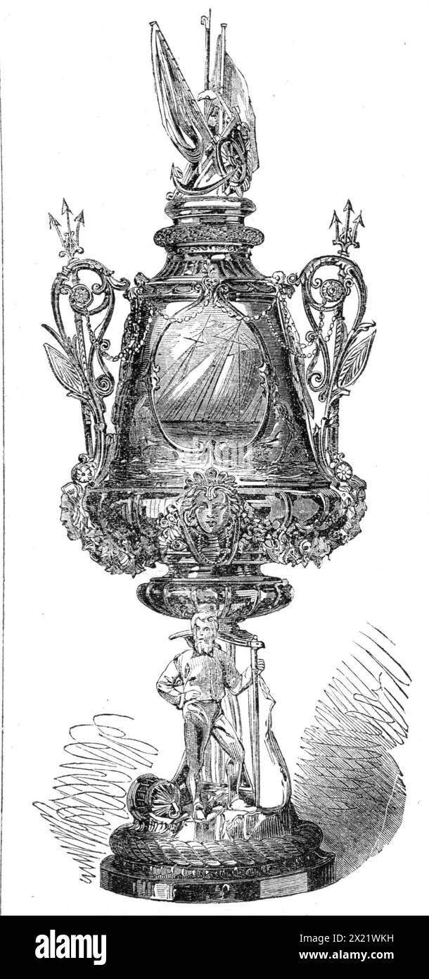 The Town Cup of the Royal Victoria Yacht Club, 1865. '...the cup...is a vase of embossed silver, on a pedestal, with the figure of a yachtsman leaning on a rudder, a yacht in full sail displayed on the shield above; the handles formed of tridents, and the lid surmounted by a pair of banners, with other subordinate features. Its weight is 40 oz., and it was furnished by Mr. Barnard, silversmith, of Ryde'. From &quot;Illustrated London News&quot;, 1865. Stock Photo