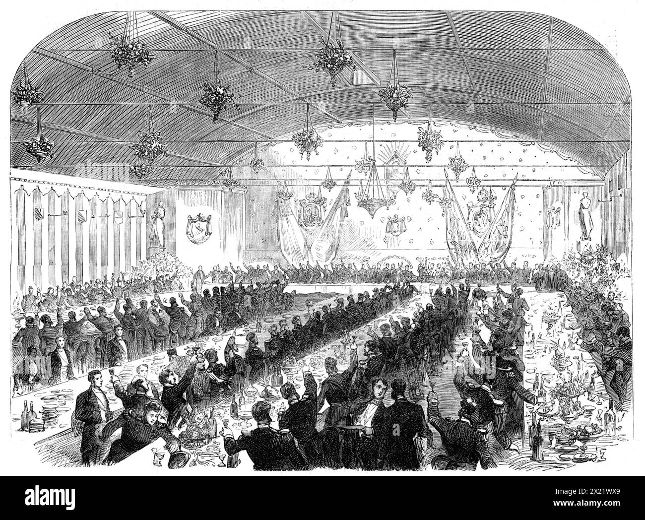 The International Naval Festival at Portsmouth: the Mayor's Banquet to the officers of the French fleet, 1865. 'The decorations, which had been intrusted to Mr. Dillon, of London, were of a novel and effective style...[The banquet was held in] one of Edgington's tents, 138 ft. long and 36 ft. wide, floored over, and lined with crimson and white cloth, also decorated with flags and coloured lamps. At the upper end, behind the Mayor's chair, was a bust of the Emperor Napoleon, above a shield bearing the arms of the town of Portsmouth, with the Mayor's chain and badge. On his right hand were the Stock Photo