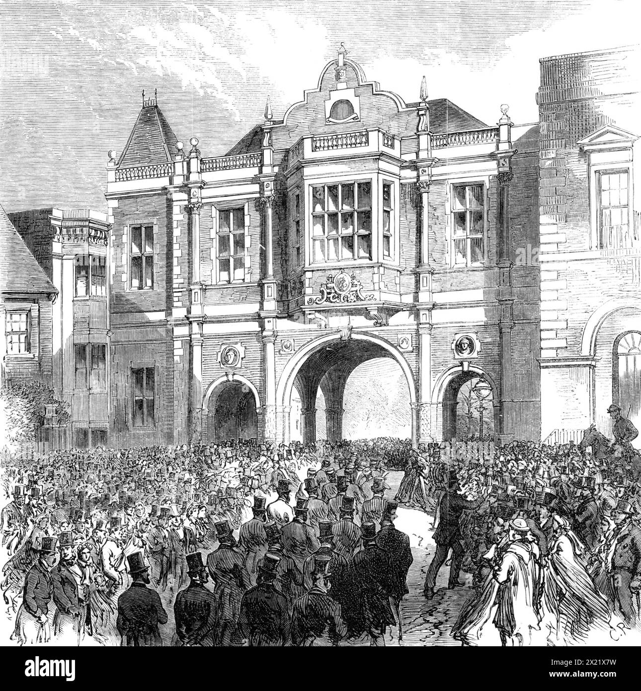 Opening of the new Corn Exchange at Aylesbury, 1865. 'The ceremony of opening the new Corn Exchange and Market-hall in the thriving town of Aylesbury took place on Wednesday week - the Right Hon. Lord Carington, Lord Lieutenant of Buckinghamshire, presiding...The site of the new Corn Exchange is in the old Market Square...The edifice, designed by Mr. D. Brandon, of Berkeley-square, is of the Elizabethan style of architecture ; the materials are red brick, with stone facings. The front, adjoining the County Hall, consists of three archways - one for carriages, the other two for foot passengers Stock Photo