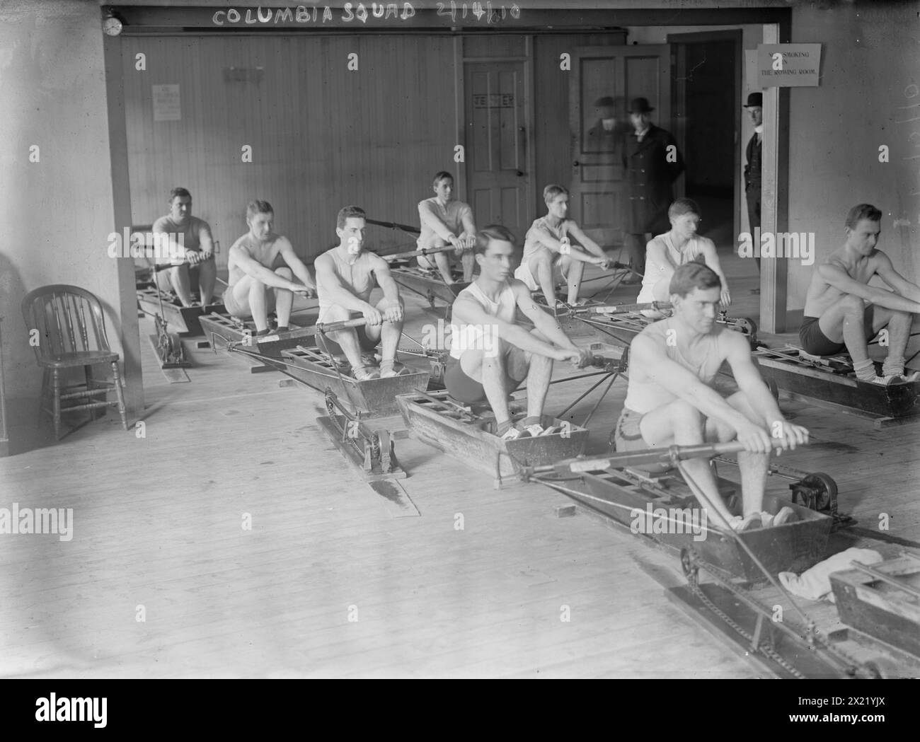 Columbia crew team in mock shells practicing in club house, 1910. Stock Photo
