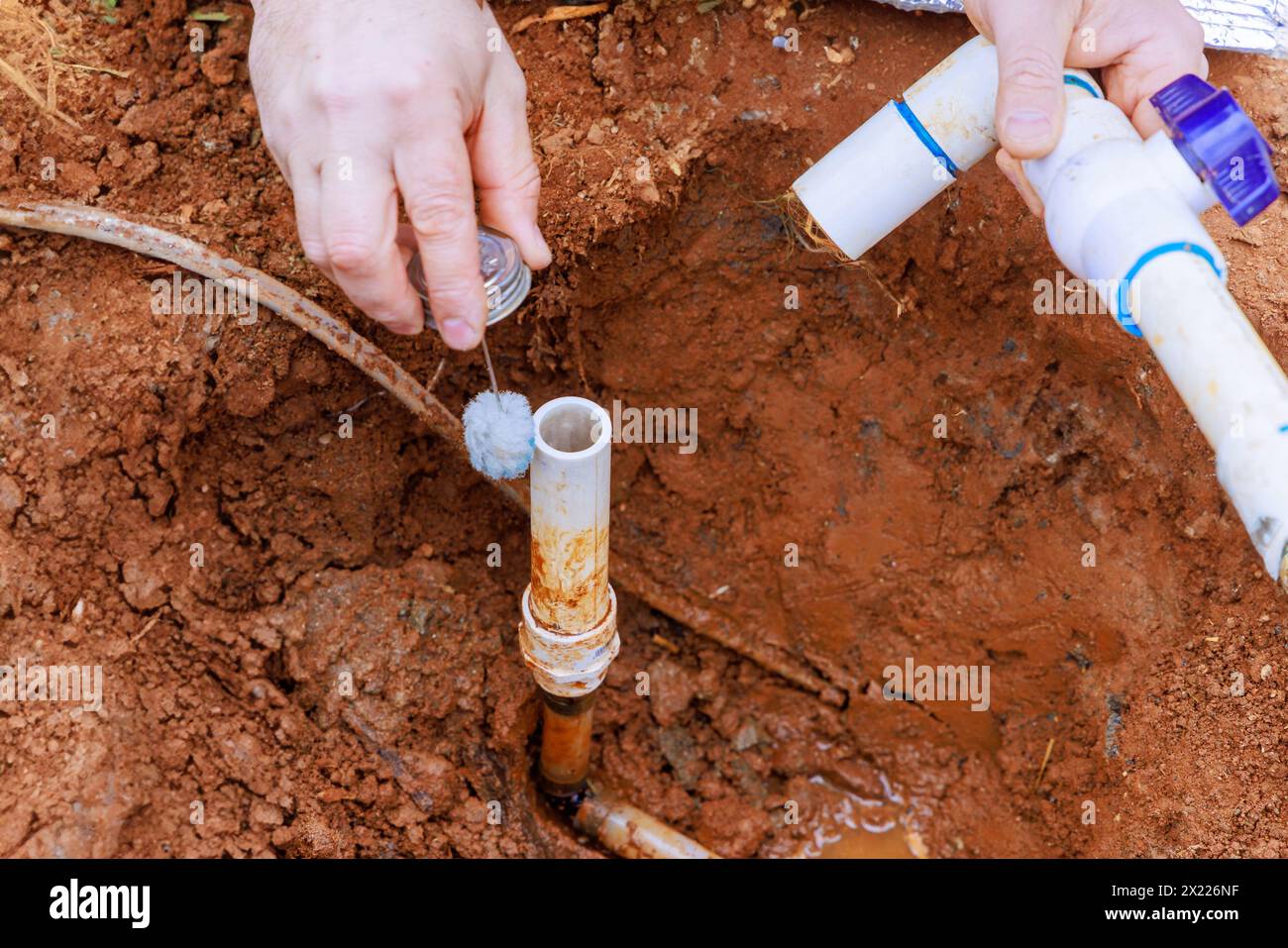 Before gluing pipes together, technician plumbers use clear primer for