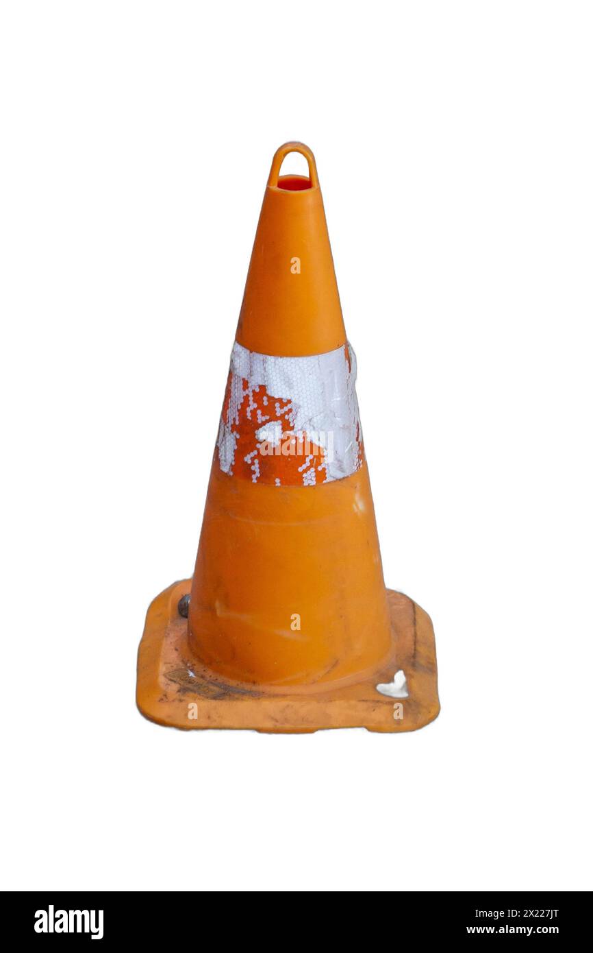 An isolated, battered traffic cone, showing signs of wear and tear