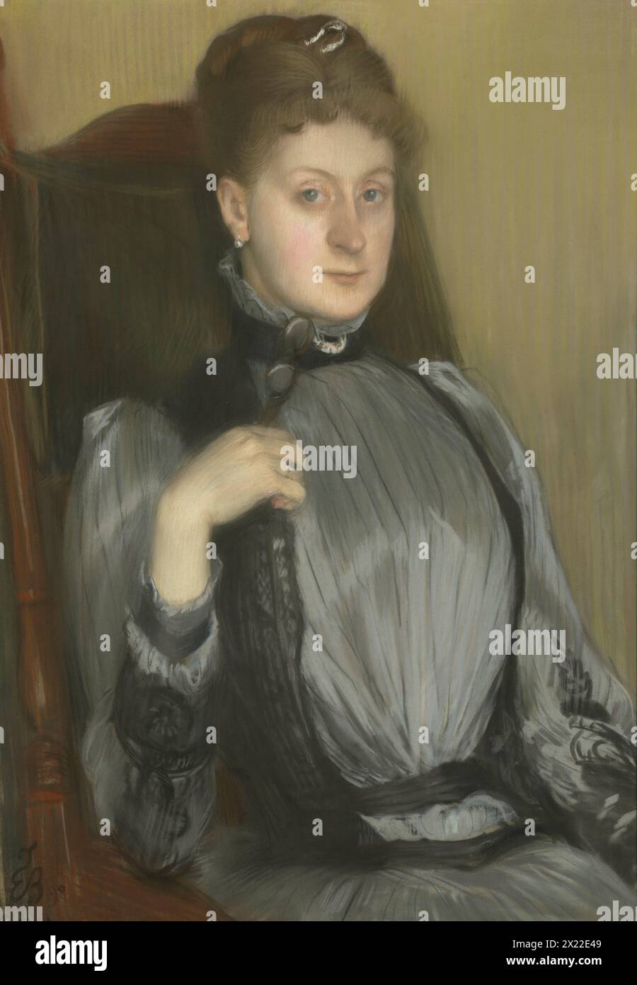 Portrait Of A Woman, 1890. Details of the sitter&#x2019;s attire and surroundings attest to her social status, from the jeweled black choker cinching the high collar of her satin dress and the pair of opera glasses clasped gently in her right hand, to the velvety chair cushion against which she rests. Stock Photo