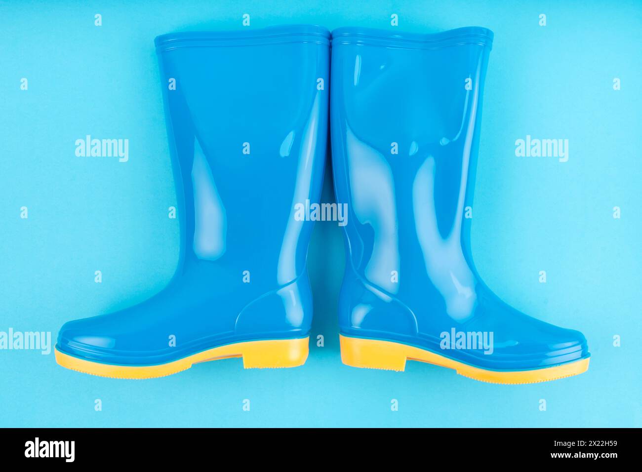 Pair of blue rubber boots on blue color background Stock Photo - Alamy